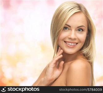 people, beauty, body and skin care concept - beautiful woman face and hands over yellow lights background