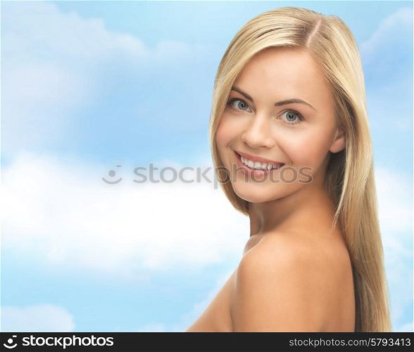 people, beauty, body and skin care concept - beautiful woman face and hands over blue sky background