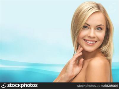 people, beauty, body and skin care concept - beautiful woman face and hands over blue waves background