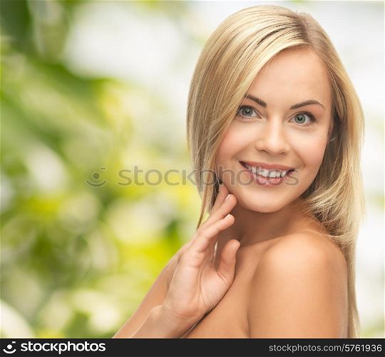 people, beauty, body and skin care concept - beautiful woman face and hands over green background