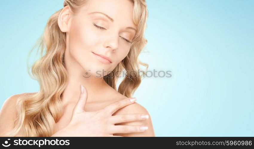 people, beauty, body and skin care concept - beautiful young happy woman with long hair over blue background