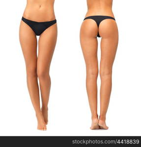 people, beauty, bodycare, underwear and slimming concept - female legs and bottom in black bikini panties over white background