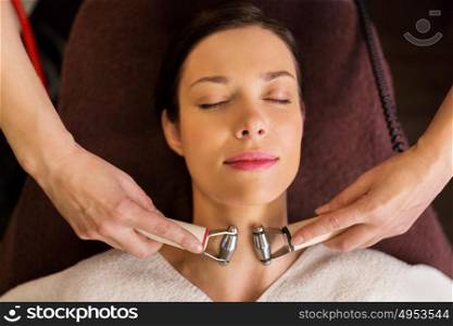 people, beauty, cosmetology and technology concept - beautiful young woman having needle free mesotherapy or hydradermie facial treatment by microcurrent firming device in spa. woman having hydradermie facial treatment in spa