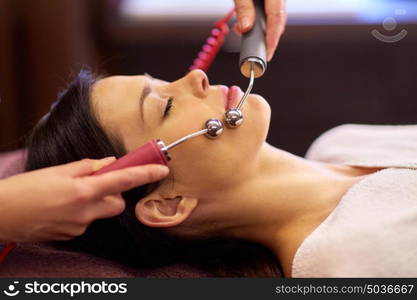 people, beauty, cosmetology and technology concept - beautiful young woman having needle free mesotherapy or hydradermie facial treatment by microcurrent firming device in spa. woman having hydradermie facial treatment in spa