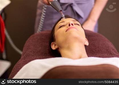people, beauty, cosmetology and technology concept - beautiful young woman having needle free mesotherapy or hydradermie facial treatment by microcurrent firming device in spa. woman having hydradermie facial treatment in spa. woman having hydradermie facial treatment in spa