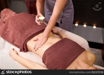 people, beauty, healthy lifestyle and relaxation concept - beautiful young woman lying and having massage with hot oil at spa. woman lying and having massage with hot oil at spa
