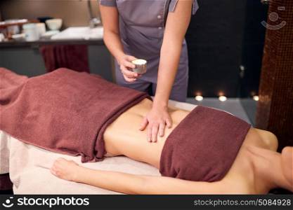 people, beauty, healthy lifestyle and relaxation concept - beautiful young woman lying and having massage with hot oil at spa. woman lying and having massage with hot oil at spa. woman lying and having massage with hot oil at spa