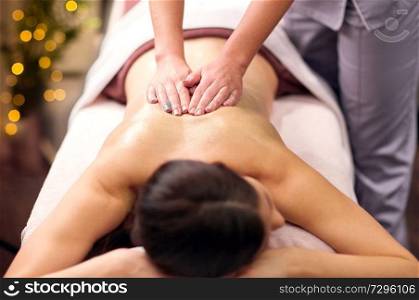 people, beauty, healthy lifestyle and relaxation concept - beautiful young woman lying and having back massage with gel at spa. woman having back massage with gel at spa