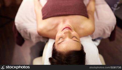 people, beauty, healthy lifestyle and relaxation concept - happy young woman lying at spa or massage parlor. happy young woman lying at spa or massage parlor