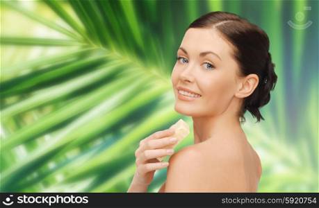 people, beauty, hygiene and summer concept - beautiful woman with soap bar over green palm leaf background