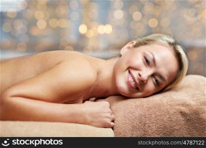 people, beauty, spa, healthy lifestyle and relaxation concept - beautiful young woman lying on massage table in spa