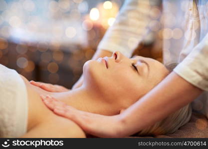 people, beauty, spa, healthy lifestyle and relaxation concept - close up of beautiful young woman lying with closed eyes and having massage in spa