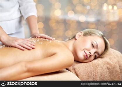people, beauty, spa, healthy lifestyle and relaxation concept - close up of beautiful young woman lying with closed eyes and having salt massage l in spa