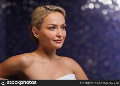 people, beauty, spa, healthy lifestyle and relaxation concept - close up of beautiful young woman sitting in bath towel