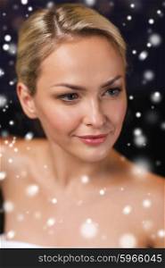people, beauty, spa, healthy lifestyle and relaxation concept - close up of beautiful young woman in bath towel at sauna with snow effect