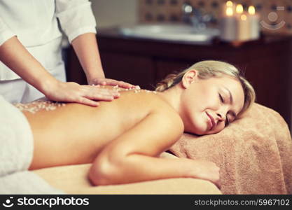 people, beauty, spa, healthy lifestyle and relaxation concept - close up of beautiful young woman lying with closed eyes and having salt massage l in spa