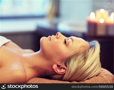 people, beauty, spa, healthy lifestyle and relaxation concept - close up of beautiful young woman lying with closed eyes in spa