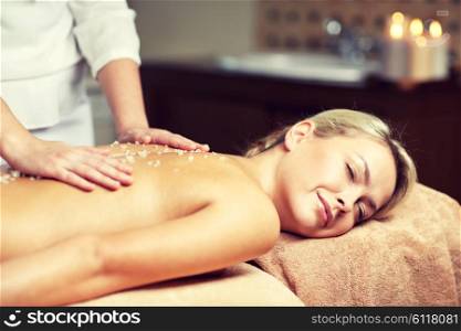 people, beauty, spa, healthy lifestyle and relaxation concept - close up of beautiful young woman lying with closed eyes and having salt massage l in spa