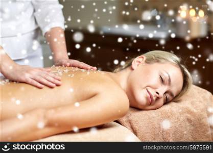 people, beauty, spa, winter and relaxation concept - close up of beautiful young woman lying with closed eyes and having salt back massage in spa with snow effect