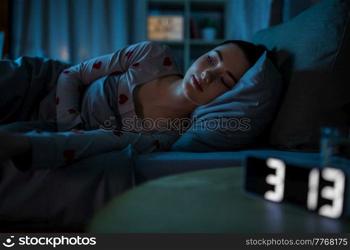 people, bedtime and insomnia concept - awake teenage girl lying at home at night. awake teenage girl lying at home at night