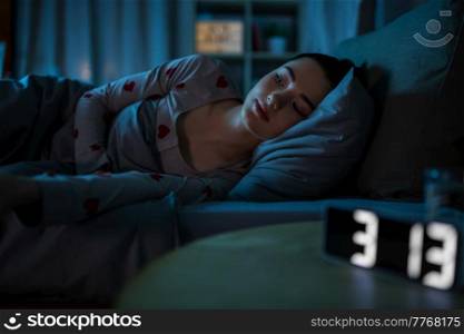 people, bedtime and insomnia concept - awake teenage girl lying at home at night. awake teenage girl lying at home at night