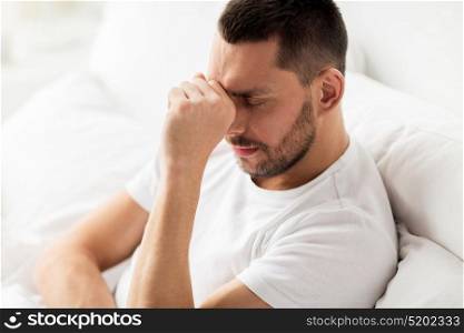 people, bedtime and rest concept - close up of stressed man in bed at home. close up of stressed man in bed at home
