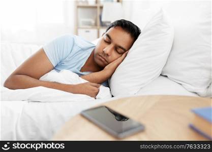 people, bedtime and rest concept - indian man sleeping in bed at home. indian man sleeping in bed at home