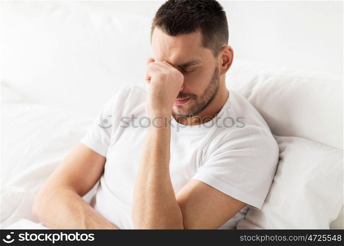 people, bedtime and rest concept - stressed man in bed at home. stressed man in bed at home