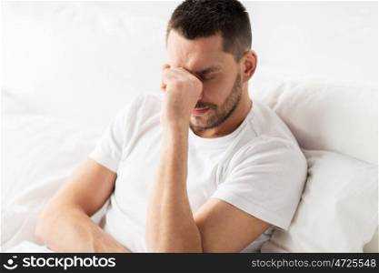 people, bedtime and rest concept - stressed man in bed at home. stressed man in bed at home