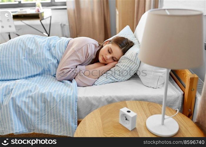 people, bedtime and rest concept - teenage girl sleeping in bed at home in morning. girl sleeping in bed at home in morning