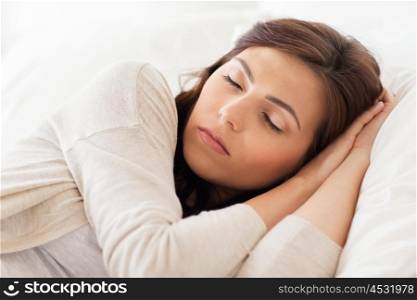 people, bedtime and rest concept - young woman sleeping in bed at home