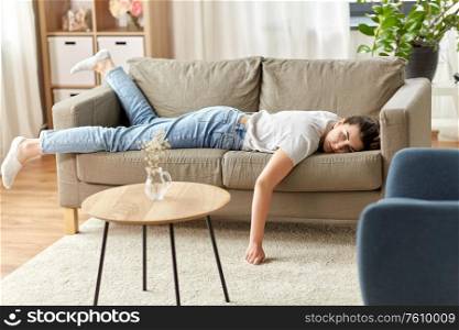 people, boredom and depression concept - bored or lazy young woman lying on sofa at home. bored or lazy young woman lying on sofa at home