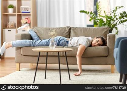 people, boredom and depression concept - bored or lazy young woman lying on sofa at home. bored or lazy young woman lying on sofa at home