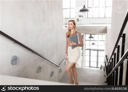 people, business and career concept - happy smiling woman with folder walking upstairs. happy woman with folder walking upstairs