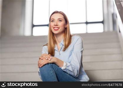 people, business and education concept - happy smiling woman or student sitting on stairs. happy smiling woman or student sitting on stairs. happy smiling woman or student sitting on stairs
