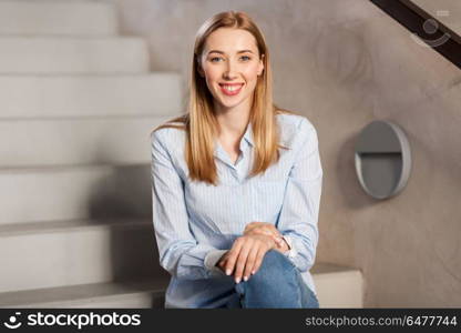 people, business and education concept - happy smiling woman or student sitting on stairs. happy smiling woman or student sitting on stairs. happy smiling woman or student sitting on stairs