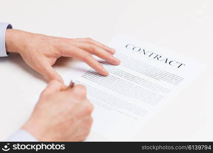 people, business and paperwork concept - close up of male hands signing contract document at office