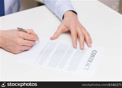 people, business and paperwork concept - close up of male hands signing contract document at office