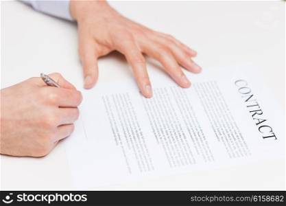 people, business and paperwork concept - close up of male hands signing contract document at office