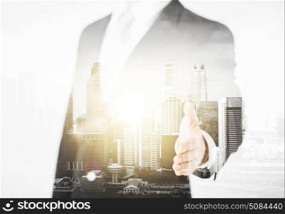 people, business and partnership concept - businessman hand ready for handshake over city with double exposure. businessman with open hand ready for handshake. businessman with open hand ready for handshake