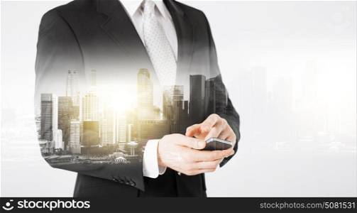 people, business and technology concept - close up of businessman with smartphone over city with double exposure. close up of businessman with smartphone