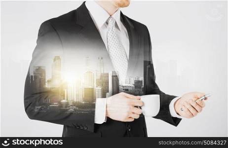 people, business and technology concept - close up of businessman with smartphone and cup of coffee over city with double exposure. businessman with smartphone and cup of coffee. businessman with smartphone and cup of coffee
