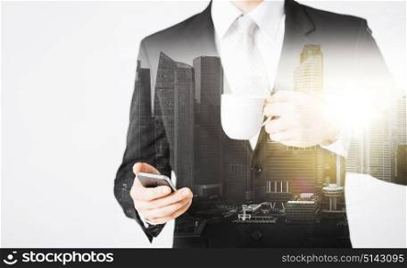 people, business and technology concept - close up of businessman with smartphone and cup of coffee over city with double exposure. businessman with smartphone and cup of coffee