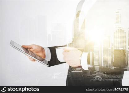 people, business and technology concept - close up of businessman with tablet pc computer and cup of coffee over city with double exposure. close up of businessman with tablet pc and coffee