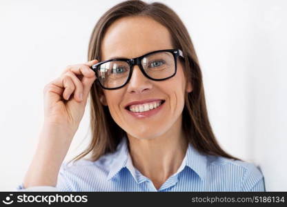people, business and vision concept - close up of happy smiling middle aged woman in glasses. close up of smiling middle aged woman in glasses