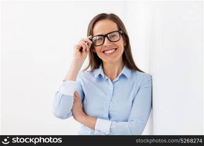 people, business and vision concept - happy smiling middle aged woman in glasses at office. happy smiling middle aged woman in glasses