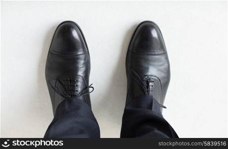 people, business, fashion and footwear concept - close up of man legs in elegant shoes with laces or lace boots