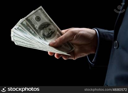 people, business, finances and money concept - close up of businessman hands holding dollar cash over black background