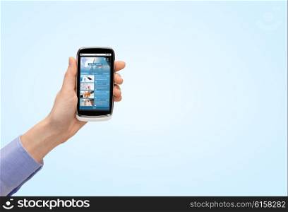 people, business, mass media, internet and technology concept - close up of woman hand with smartphone with news web page on screen