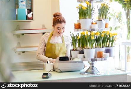 people, business, sale and floristry and concept - happy smiling florist woman at flower shop cashbox on counter